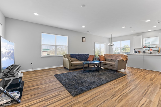 living room featuring a chandelier and light wood-type flooring