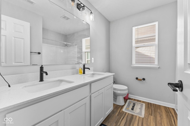 bathroom featuring vanity, hardwood / wood-style floors, toilet, and a shower