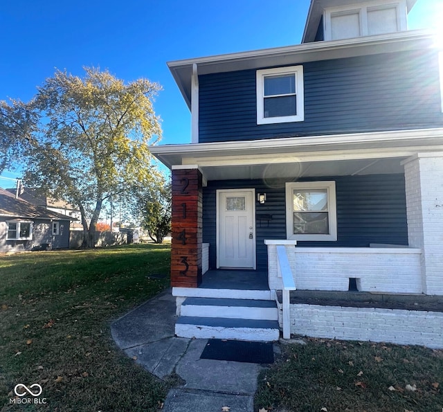 doorway to property featuring a lawn