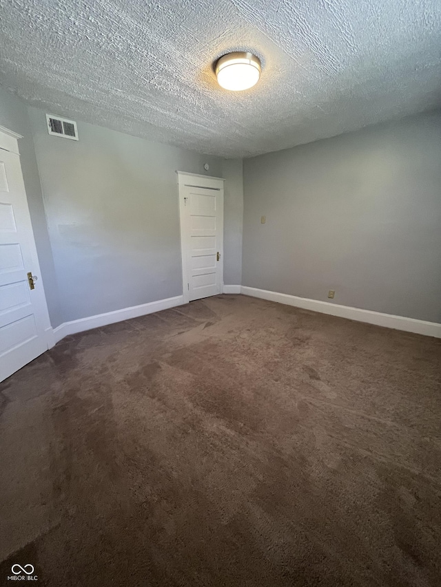 carpeted spare room with a textured ceiling