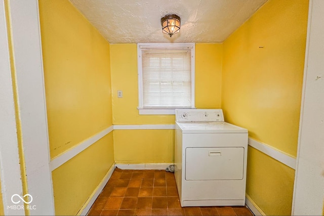 clothes washing area with washer / dryer and a textured ceiling