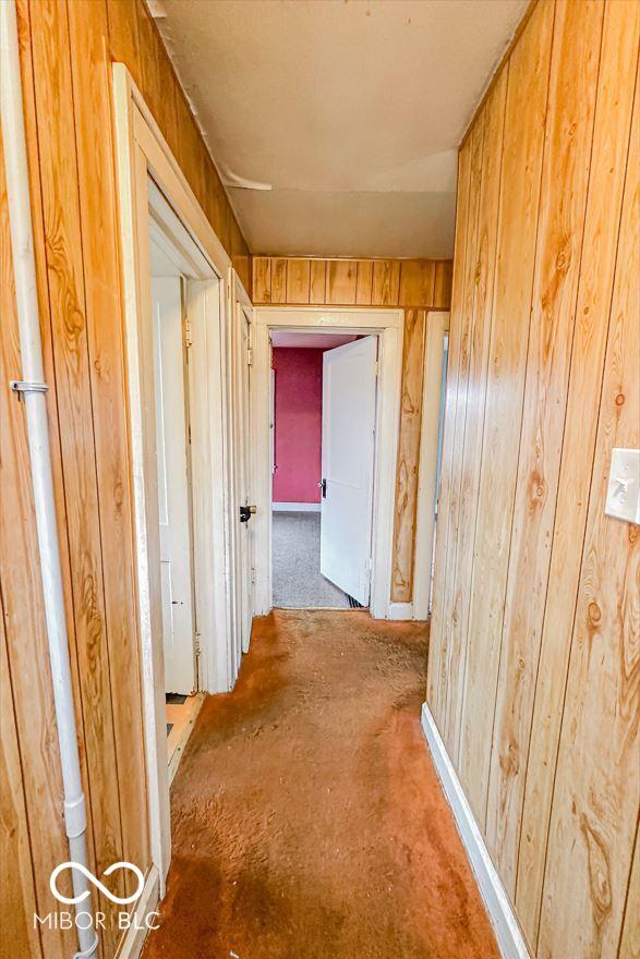 hallway with wood walls