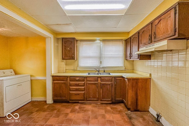 kitchen featuring washer / dryer, sink, and decorative backsplash