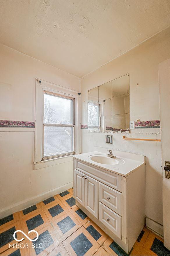 bathroom featuring vanity, tile walls, and a textured ceiling