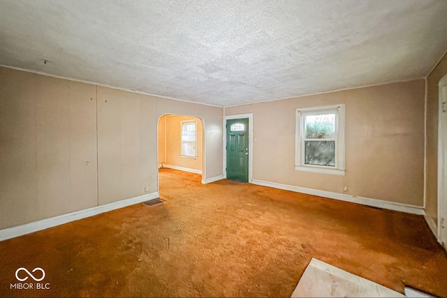 spare room featuring carpet floors and a textured ceiling