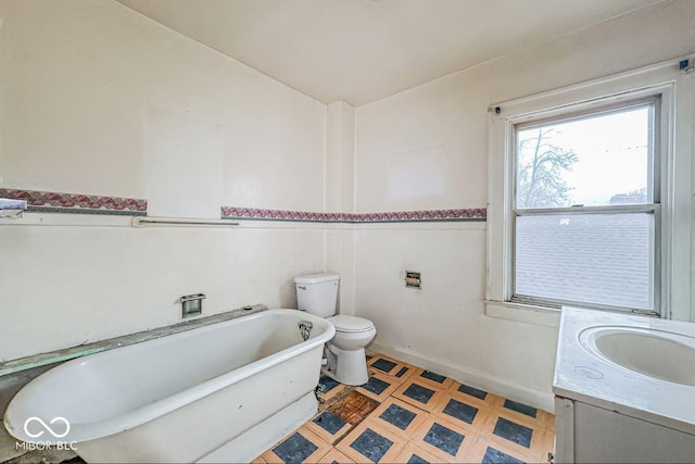 bathroom featuring vanity, a bath, and toilet