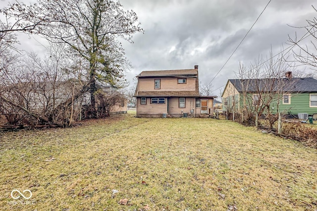 rear view of property featuring a lawn