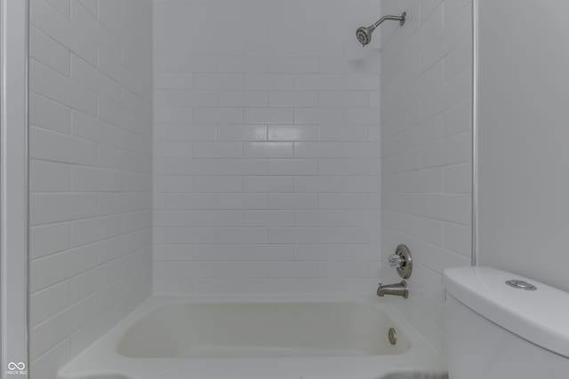 bathroom with tiled shower / bath and toilet