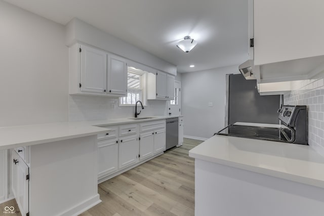 kitchen featuring sink, white cabinets, stainless steel appliances, light hardwood / wood-style floors, and backsplash