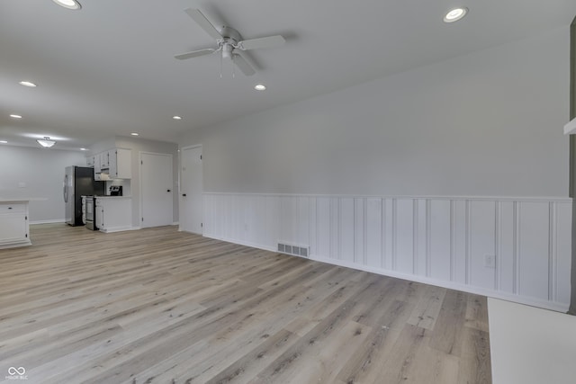 unfurnished living room featuring ceiling fan and light hardwood / wood-style flooring