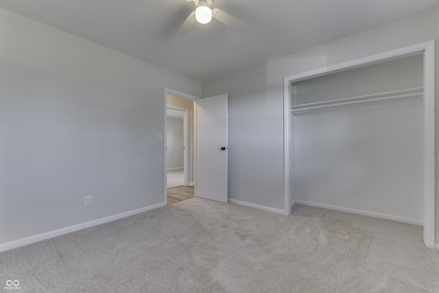 unfurnished bedroom with ceiling fan, a closet, and light carpet