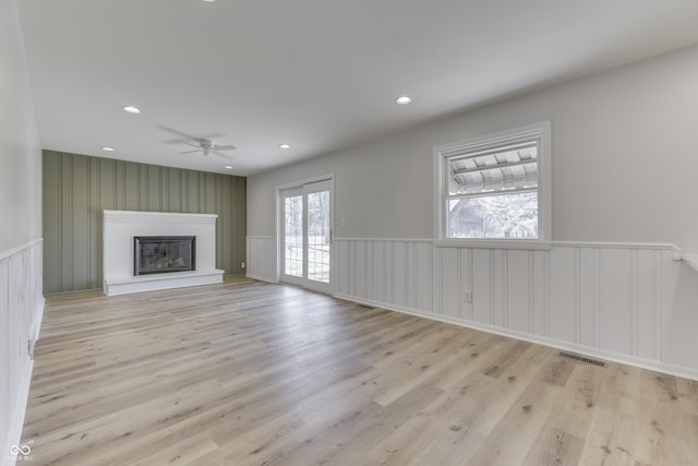 unfurnished living room with ceiling fan and light wood-type flooring