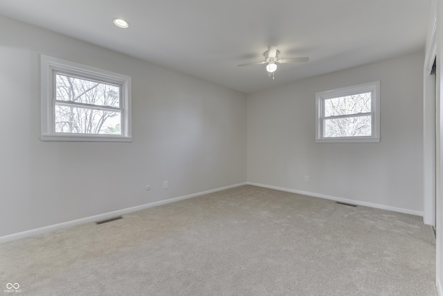 spare room with ceiling fan and light carpet