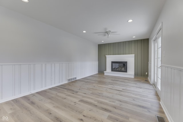 unfurnished living room featuring ceiling fan and light hardwood / wood-style floors