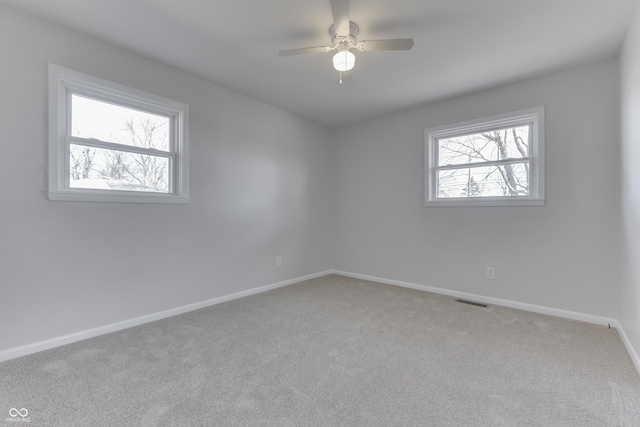 carpeted empty room with plenty of natural light and ceiling fan