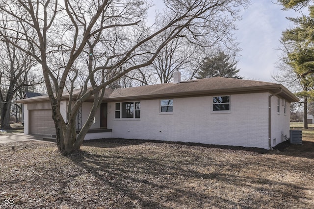 view of front of property with a garage and central air condition unit