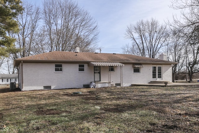 back of property featuring a lawn and central air condition unit