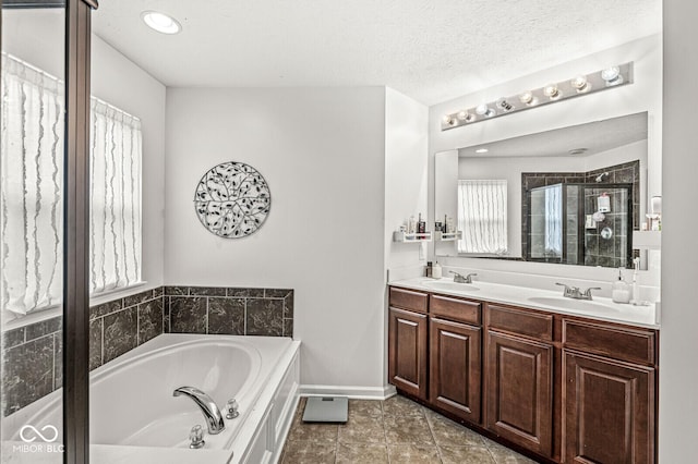 bathroom with vanity, tile patterned floors, shower with separate bathtub, and a textured ceiling