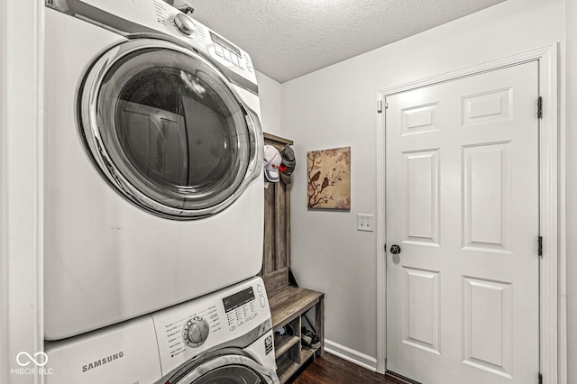 laundry area with stacked washer / dryer, dark hardwood / wood-style floors, and a textured ceiling