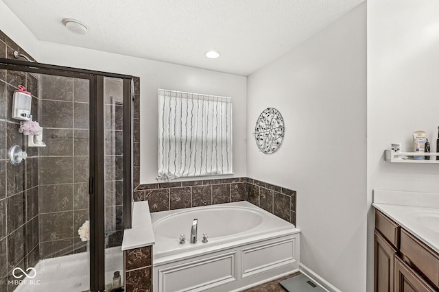 bathroom with vanity, independent shower and bath, and a textured ceiling