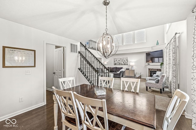 dining room featuring an inviting chandelier, a premium fireplace, and dark hardwood / wood-style flooring