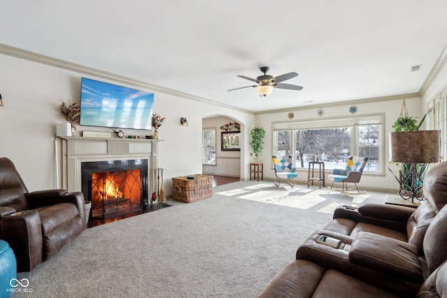 carpeted living room with ornamental molding and ceiling fan