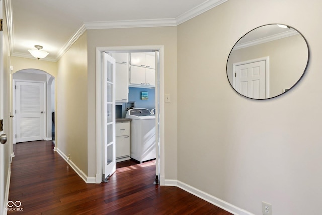 hallway with dark wood-type flooring, ornamental molding, and washer / dryer