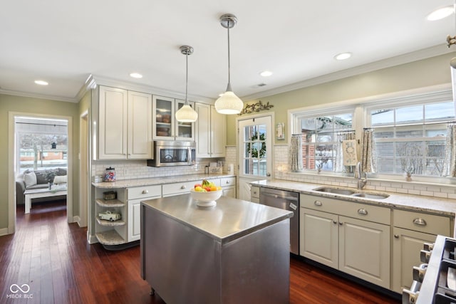 kitchen with sink, stainless steel appliances, a kitchen island, dark hardwood / wood-style flooring, and decorative light fixtures