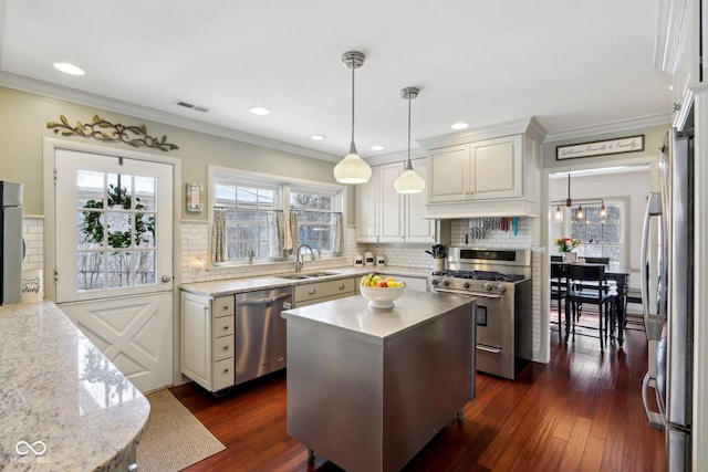 kitchen featuring a kitchen island, appliances with stainless steel finishes, sink, dark hardwood / wood-style flooring, and hanging light fixtures