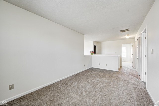 carpeted spare room featuring a textured ceiling