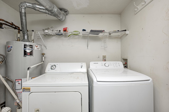 clothes washing area with washer and clothes dryer and gas water heater