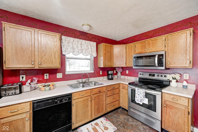 kitchen with appliances with stainless steel finishes, sink, and a textured ceiling