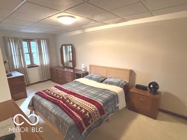 bedroom featuring a paneled ceiling and light colored carpet