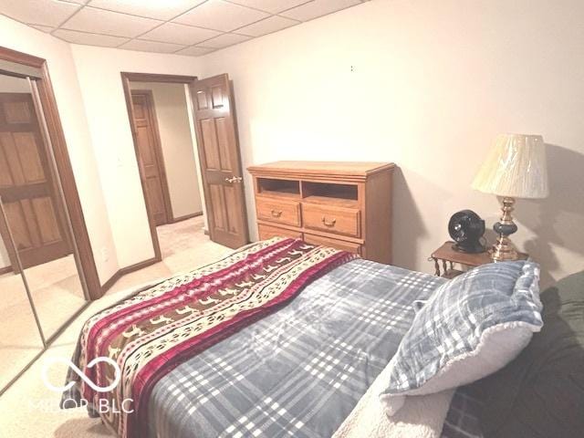 bedroom with light carpet and a drop ceiling