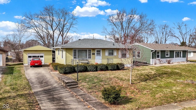 single story home featuring an outbuilding, a garage, and a front lawn