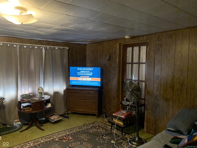 carpeted living room featuring wooden walls