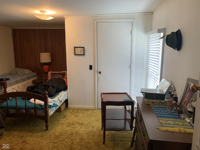 bedroom with light carpet and wood walls