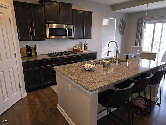 kitchen featuring black gas stovetop, sink, a center island with sink, and dark hardwood / wood-style floors