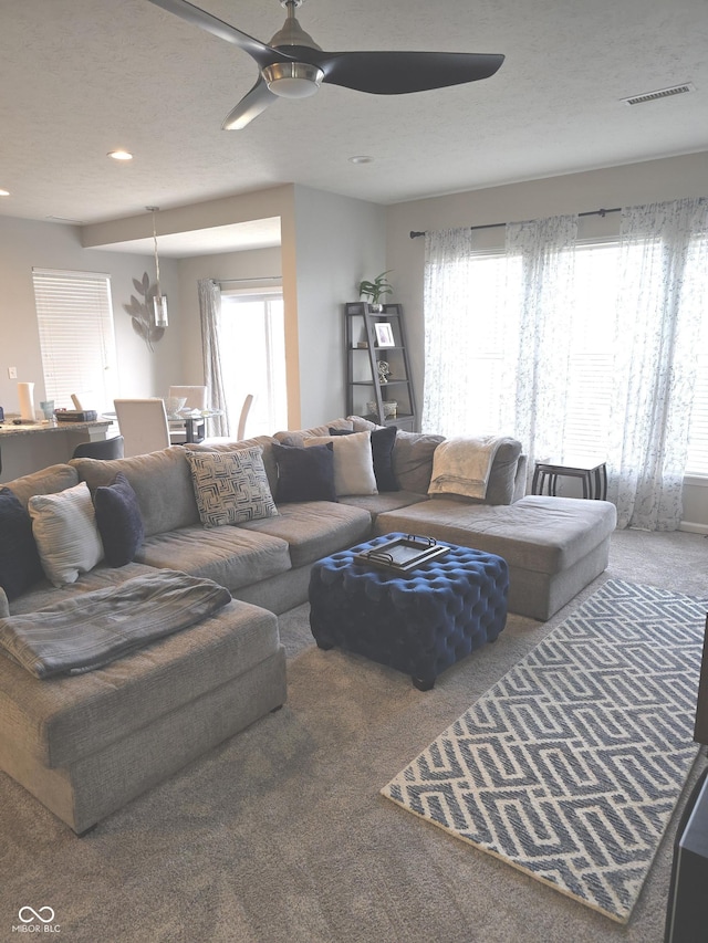 carpeted living room with ceiling fan