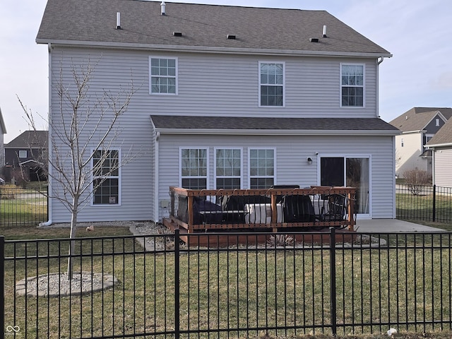 rear view of property featuring a deck and a lawn