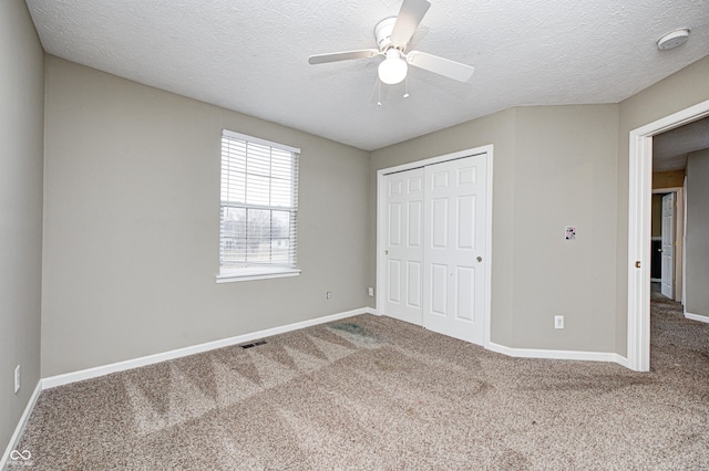 unfurnished bedroom featuring carpet floors, a closet, visible vents, and baseboards