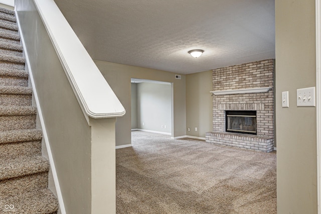 unfurnished living room featuring carpet, a fireplace, a textured ceiling, baseboards, and stairs