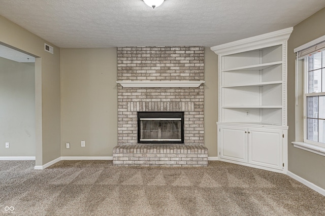 unfurnished living room with a textured ceiling, a fireplace, visible vents, and carpet flooring