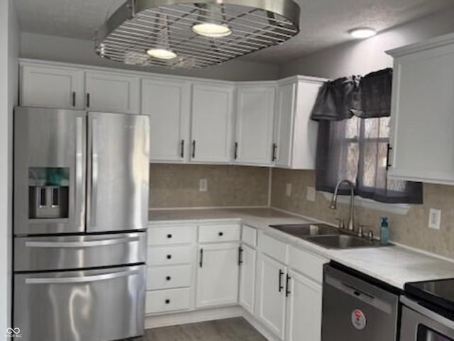 kitchen with stainless steel fridge, black dishwasher, sink, and white cabinets