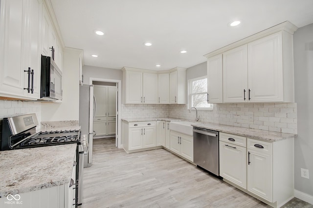 kitchen featuring appliances with stainless steel finishes, sink, and white cabinets