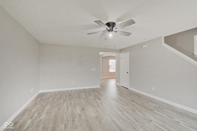 spare room with ceiling fan, light hardwood / wood-style flooring, and a textured ceiling