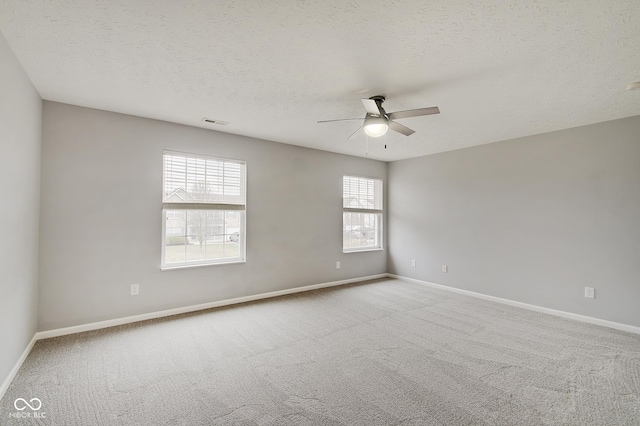 unfurnished room featuring ceiling fan, light carpet, and a textured ceiling