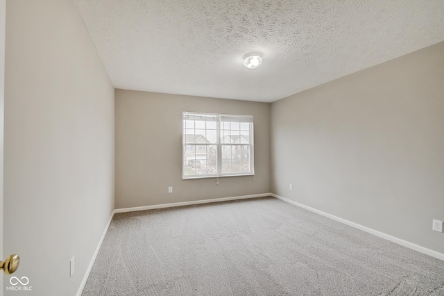 carpeted empty room with a textured ceiling