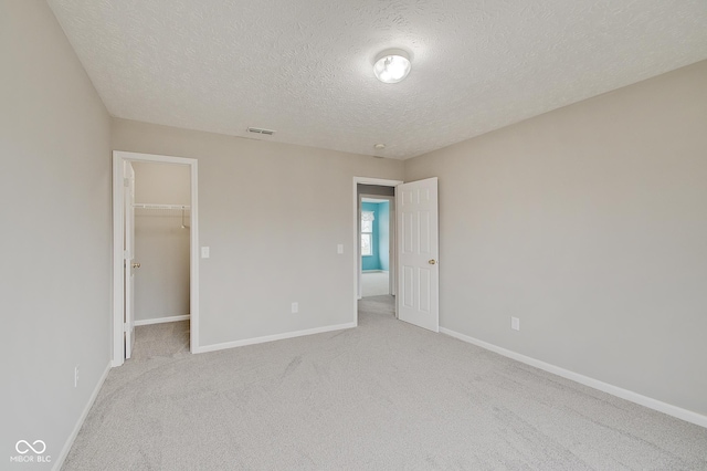 carpeted empty room with a textured ceiling