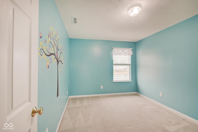 empty room with carpet flooring and a textured ceiling